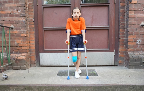Little,Girl,With,Crutches,At,The,Stair.,Back,To,School - Queens School Accident Attorney New York School Injury Lawyers